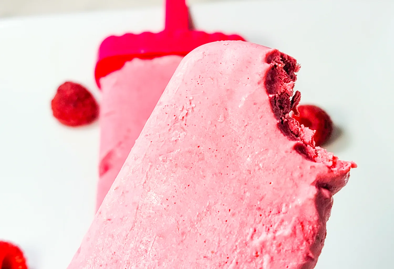 Raspberry Creamsicle Popsicles for keto with low carb ingredients on counter. 