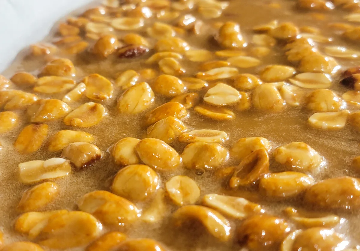 baking sheet with peanuts and candy mixture.