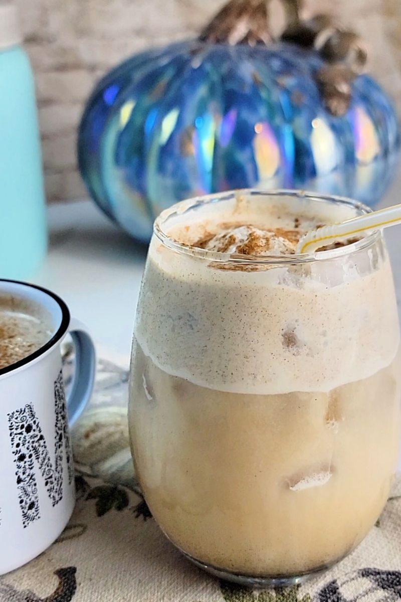 Pouring homemade pumpkin spice cold foam over iced cold brew coffee