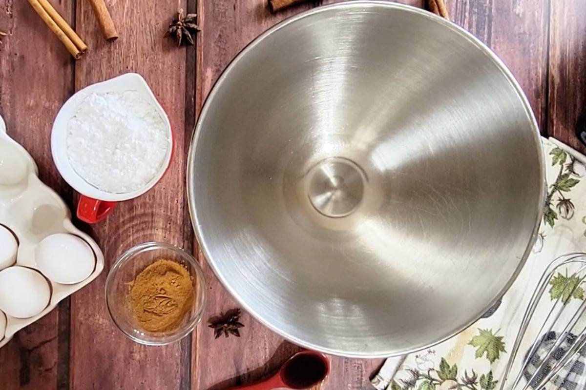 ingredients next to mixing bowl including cinnamon, eggs, pumpkin